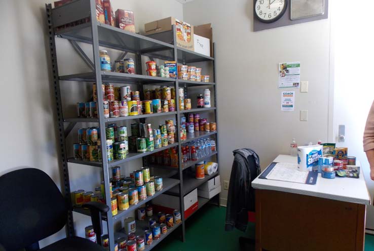 A shelf full of various food items and supplies in the COACH Cupboard room.